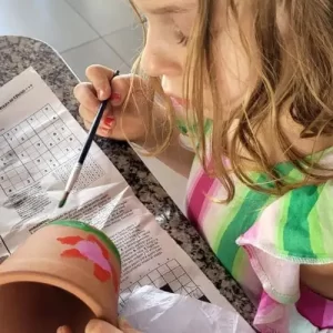 Crianças pintando vasinhos em oficina infantil